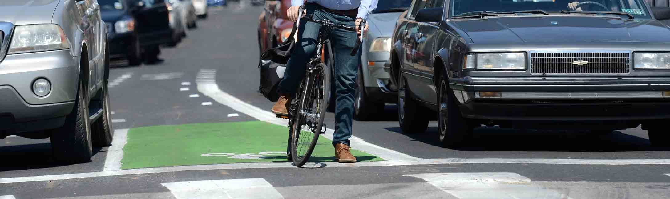 bicyclist waiting at intersection in marked bike lane